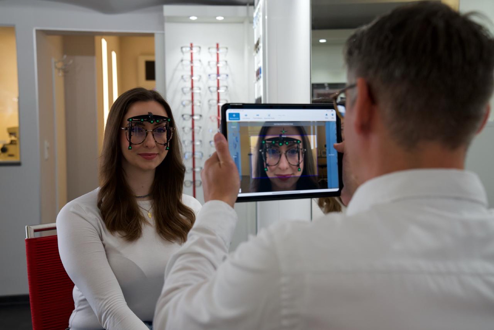 Optiker fotografiert Kundin mit Messaufsatz, OptikamPad ermittelt alle Werte